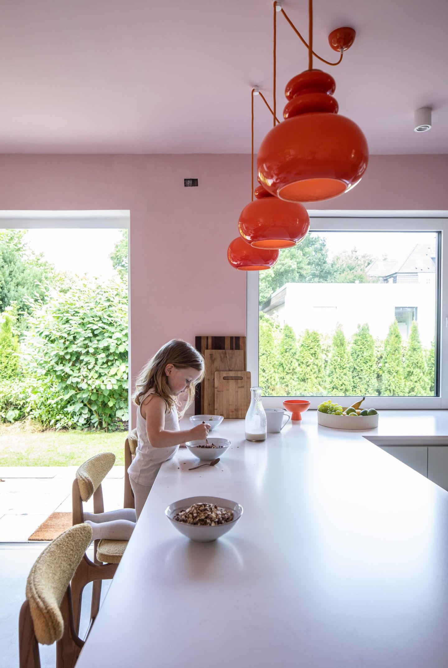 Küchentresen mit Mädchen und rosafarbener Wand im Hintergrund