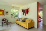 Wohnzimmer in Pistaziengrün mit einem gelben Sofa