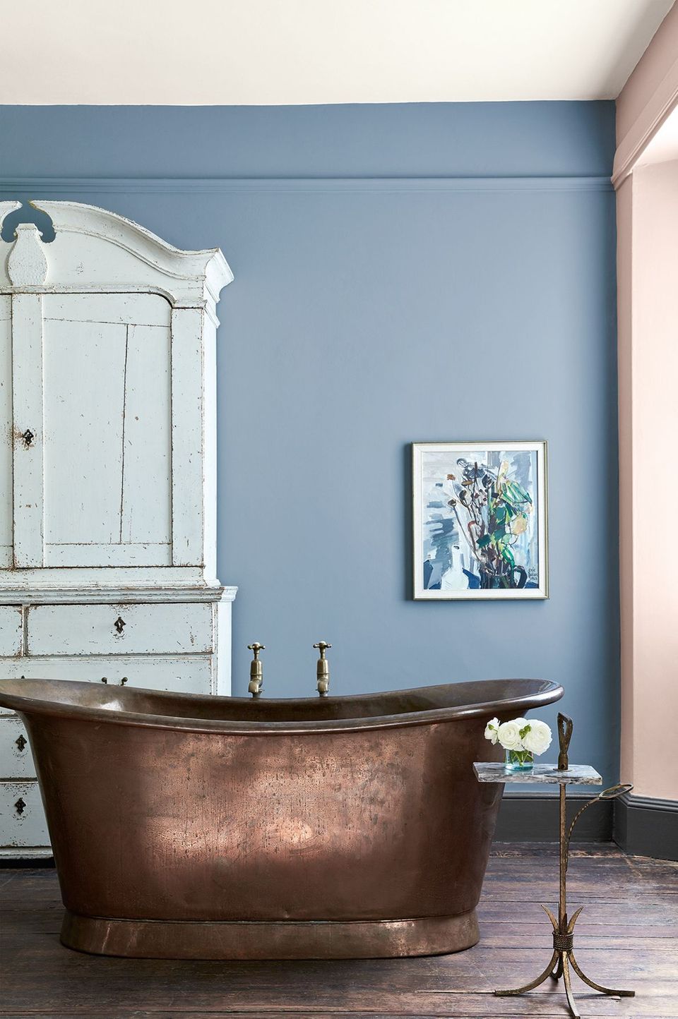 Raum mit graublauer Wand und einer bronzefarbenen Vintage-Badewanne