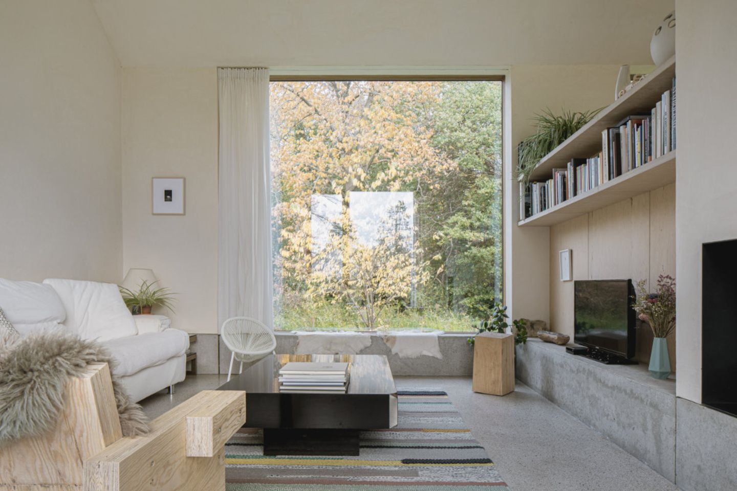 Wohnraum mit großem Quadratfenster und Betonsockel rundherum