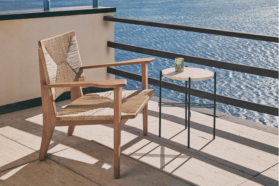 Geflochtener Loungechair auf Balkon am Meer