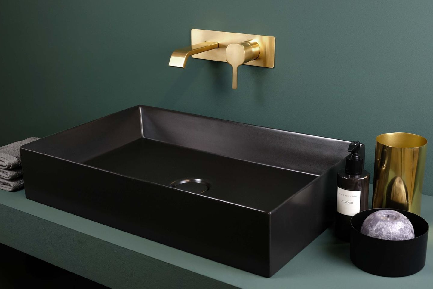 Badezimmer und Waschbecken in Tannengrün und Schwarz mit einer Unterputzarmatur in Messing