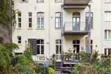 Blick auf ein Mehrfamilienhaus mit gelber Fassade und Balkonen