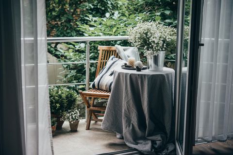 Blick auf einen Balkon mit Stuhl und Tisch und dezenter Bepflanzung