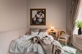 Kleines, kuscheliges Schlafzimmer in Rose mit aufgewühlten Decken auf dem Bett