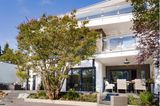 Terrasse eines modernen Wohnhauses mit Baum als Sichtschutz
