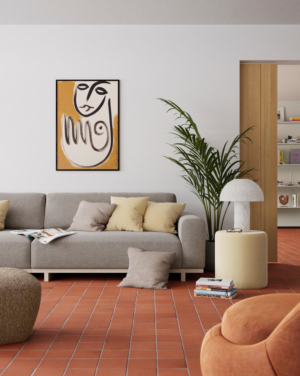 Graues Sofa von Sofacompany in einem Wohnzimmer mit rostfarbenen Fliesen