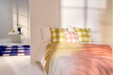 Schlafzimmer mit karierten Kissen auf dem Bett