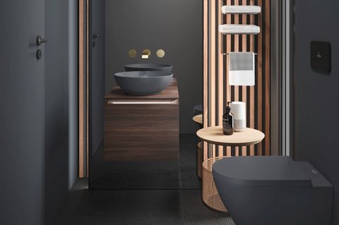 Mit hellem Holz und in Anthrazit gehaltenes japanisches Badezimmer mit Waschtischen und WC in getrennten Räumen