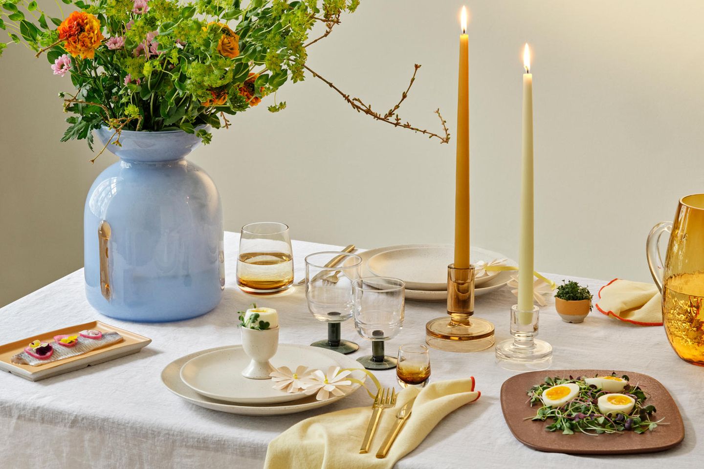 Gedeckter und dekorierter Esstisch mit Blumen und Kerzen
