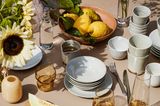 Sommerlich gedeckter Esstisch mit Zitronen und Melone