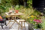 Gemütliche Sitzecke mit Bambus-Gartenmöbeln und Boho-Accessoires im Garten