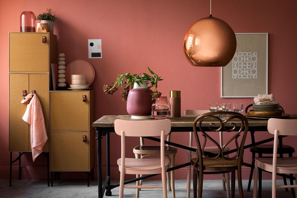 Esszimmer in Rosa, Kupfer, Senfgelb und Lachspink mit einem Holztisch und Stühlen