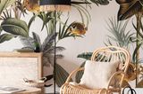 Boho-Wohnzimmer mit floraler Tapete, hellem Holz-Sideboard und Rattansessel