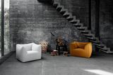 Sessel  "Le Bambole" von Mario Bellini in einem Loft aus dunkelgrauem Sichtbeton