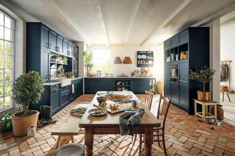 Landhausküche in Blau mit Kücheninsel und Küchenboden mit Fliesen in Terracotta