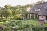 Bauerngarten mit reetgedecktem Haus