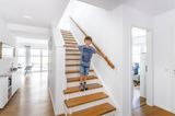 Junge auf Treppe im Fertighaus