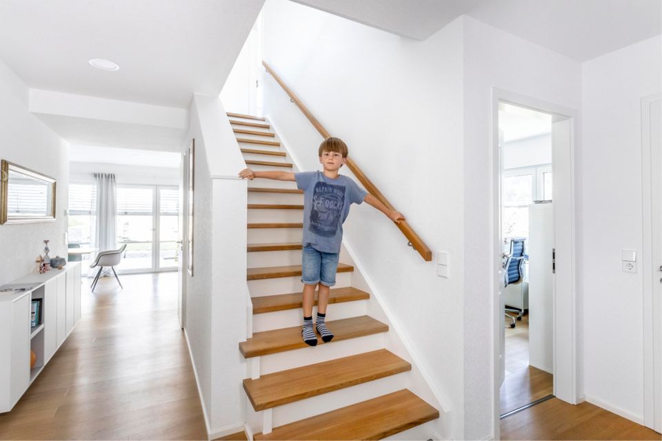 Junge auf Treppe im Fertighaus