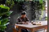Bauherrin am Esstisch mit Puzzle, im Hintergrund üppige Zimmerpflanzen