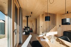 Holzverkleideter Innenraum des Ferienhauses mit Tunnelkamin