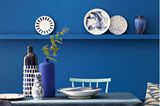 Tisch mit Vasen vor Wand in Ultramarineblau