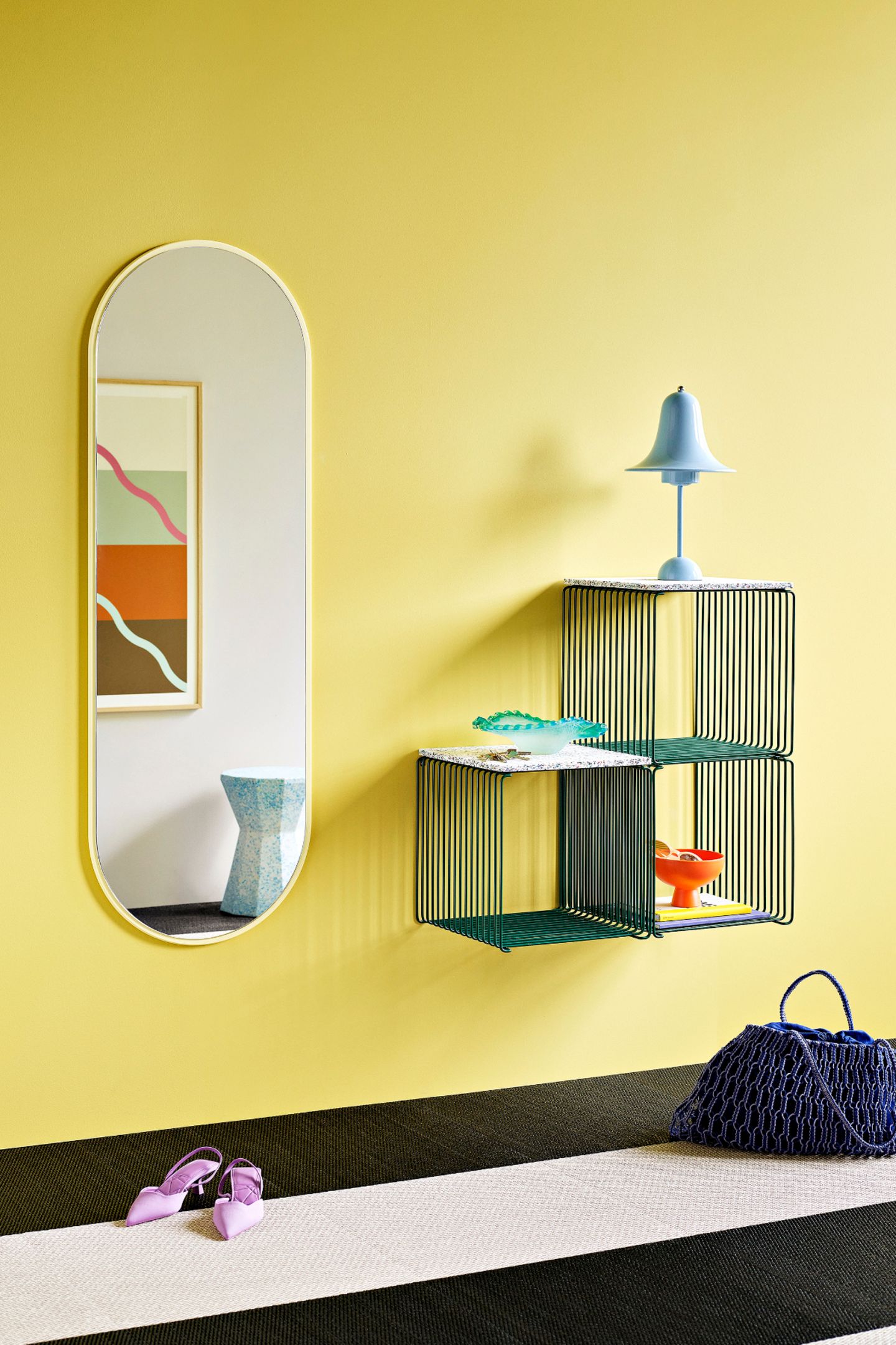 Flur mit gelben Wänden, ovalem Spiegel und Wandregal in Blau