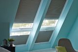 Dachfenster im Schlafzimmer mit türkisfarbener Wand und verdunkelnden Plissees von Duette