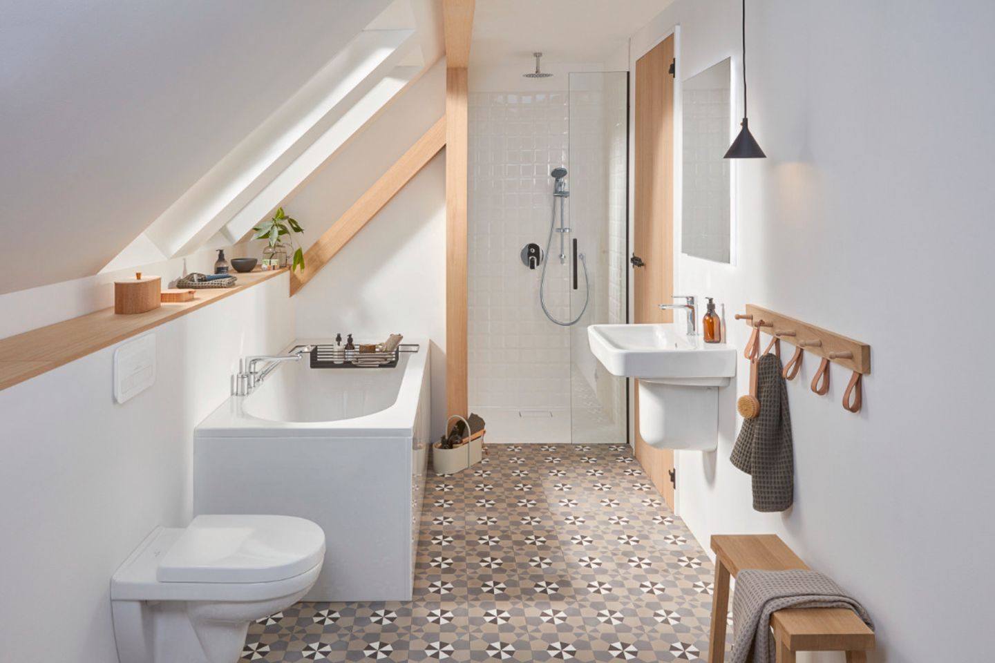 Kleines Bad in Weiß mit schönen Musterfliesen, hellem Holz und einer Badewanne unter der Dachschräge