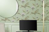 Kleiner Fernsehtisch vor einer knallig grünen Blumentapete und einem Spiegel auf der linken Seite
