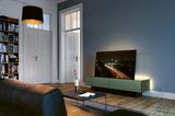 Altbau-Wohnzimmer mit TV-Möbel, das für indirekte Beleuchtung an der Rückwand sorgt.