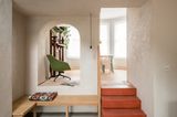 Rundbogen mit Blick in Esszimmer und dreistufige orangene Treppe