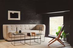 Schwarzes Wohnzimmer mit einem weißen bodentiefen Sofa als Blickfang