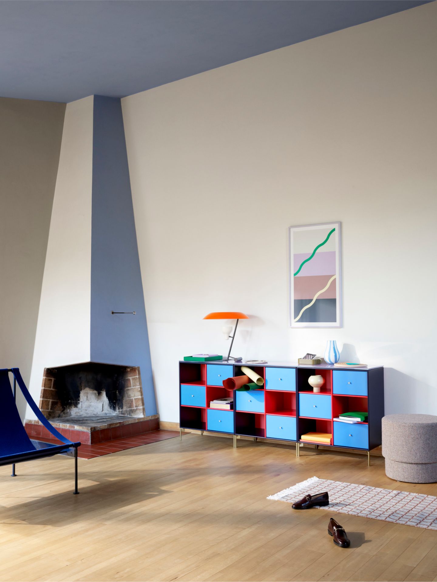 Sideboard und Sessel in geräumigem Wohnzimmer mit blauer Decke und cremefarbener Wand