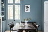 Esstisch mit Stühlen in Esszimmer mit Wand und Decke in einheitlichem Blaugrau