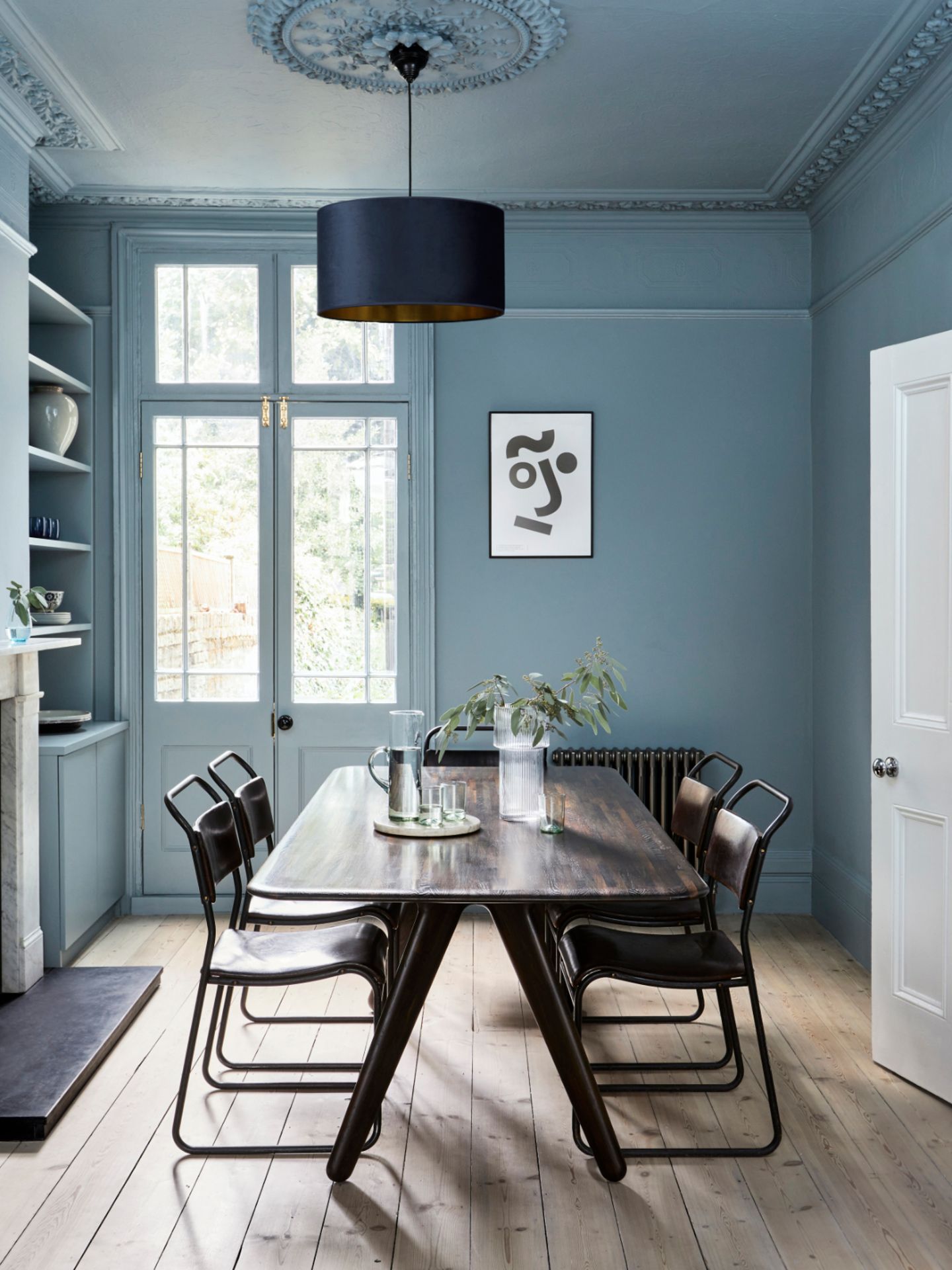 Esstisch mit Stühlen in Esszimmer mit Wand und Decke in einheitlichem Blaugrau