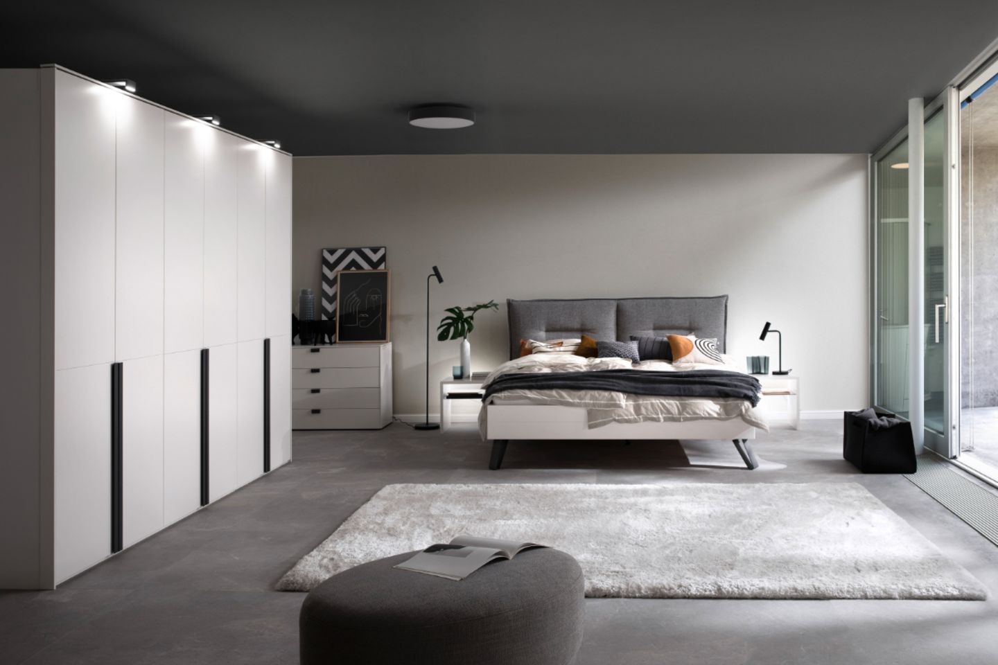 Schlafzimmer mit Doppelbett in der Mitte und dunkelgrauer Zimmerdecke