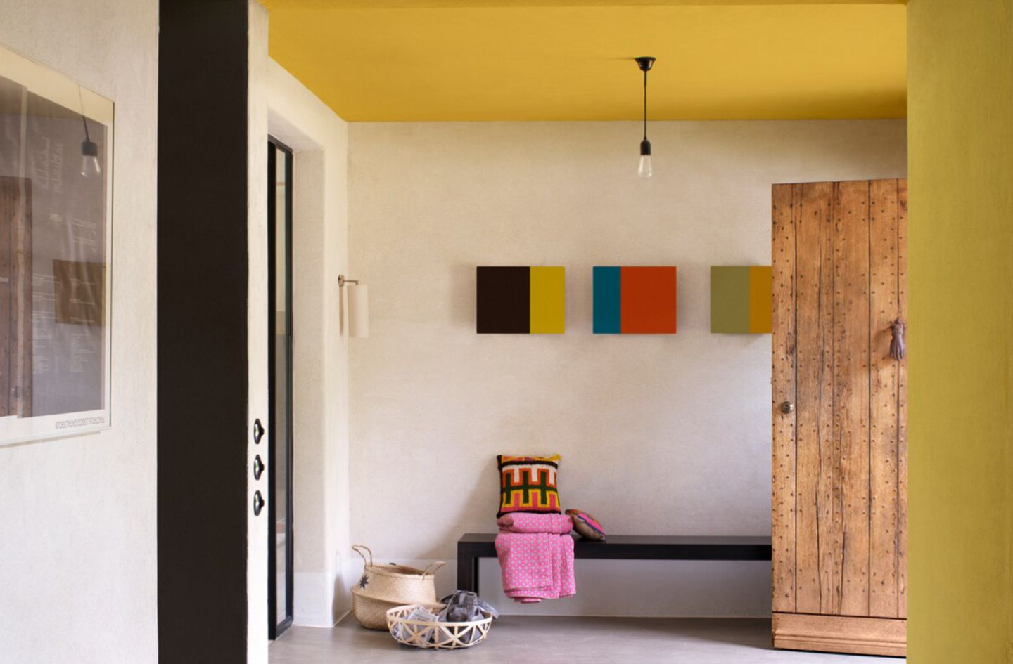 Geräumiger Eingangsbereich mit offener Haustür aus Holz und gelber Deckenfarbe