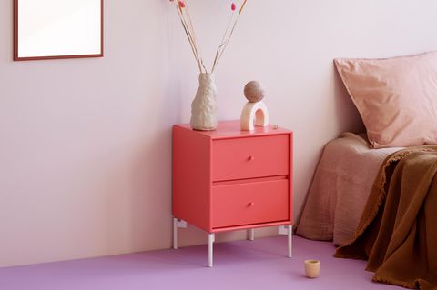 Nachttisch in Pink vor eine Schlafzimmerwand in Mauve und einem Boden in Lila