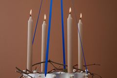 Schwebender Metallring aus Edelstahl als Aventskranz mit blauen Bändern und Kerzen in Greige