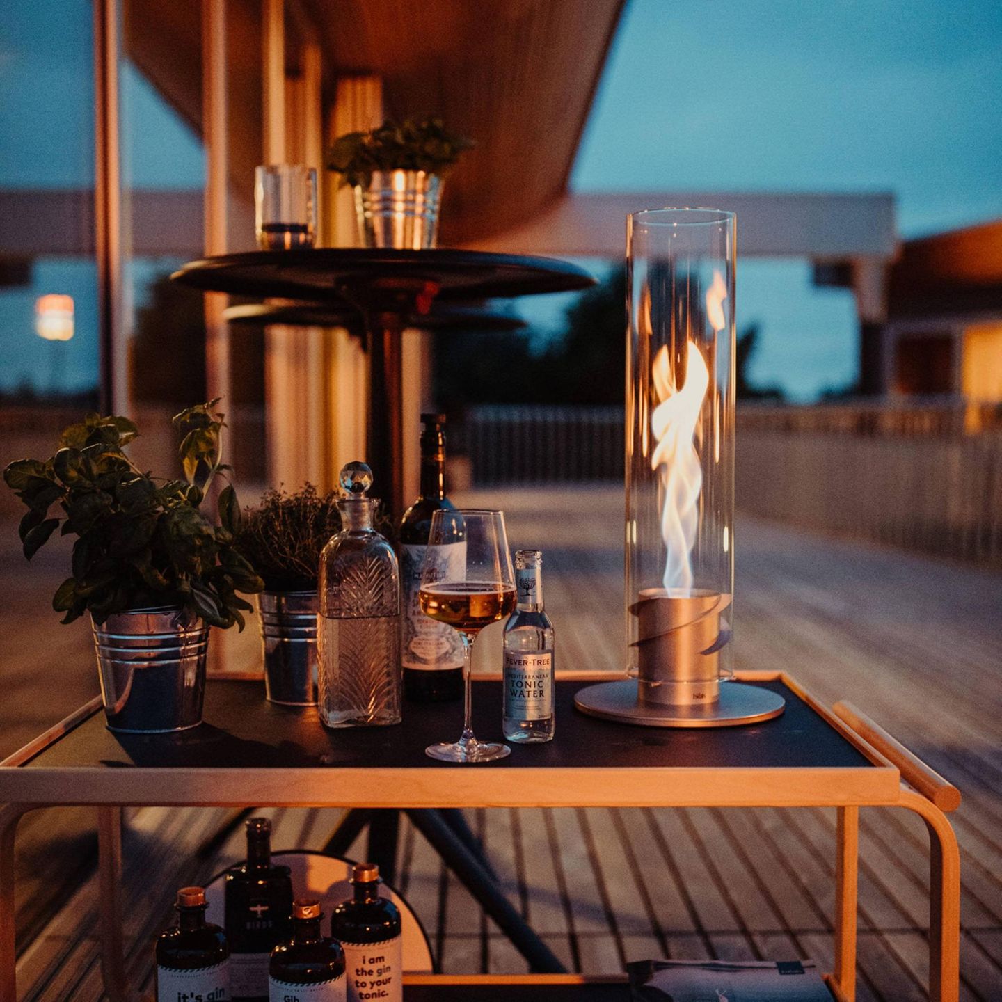 Tischfeuer in dunkler Atmosphäre, im Hintergrund eine Terrasse