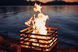 Feuerkorb vor einem See mit Sonnenuntergang