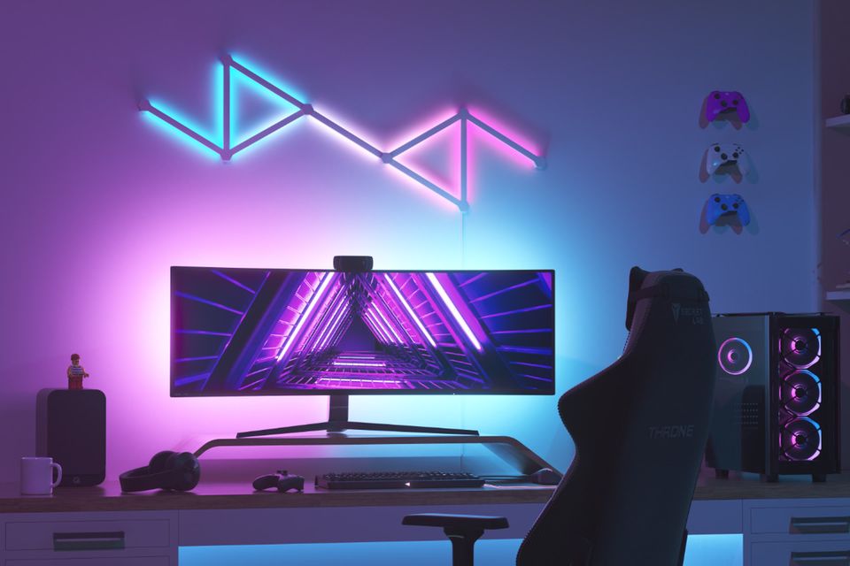 Gaming-Zimmer mit Blau und Pink leuchtenden Nanoleaf Lines an der Wand