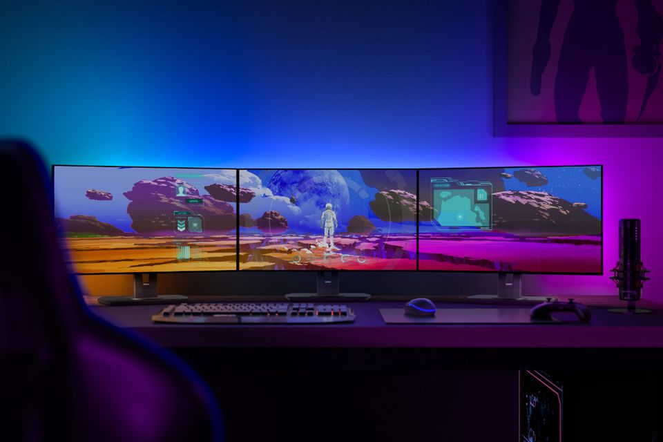 Gaming-Zimmer mit Triple-Monitor und Lightstrips von Signify