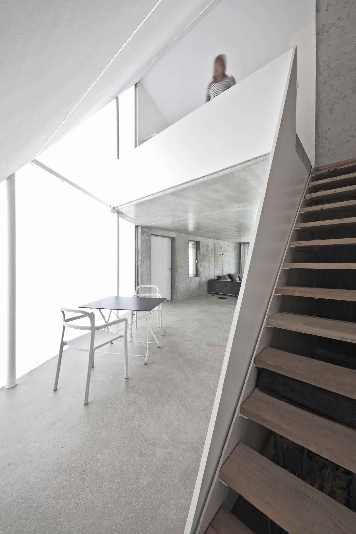 Offener Wohnraum mit steiler Treppe zur Galerie