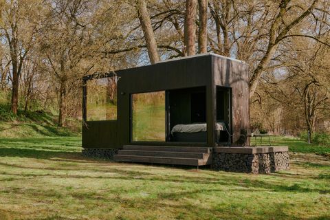 Tiny House mit schwarzer Holzfassade im Grünen