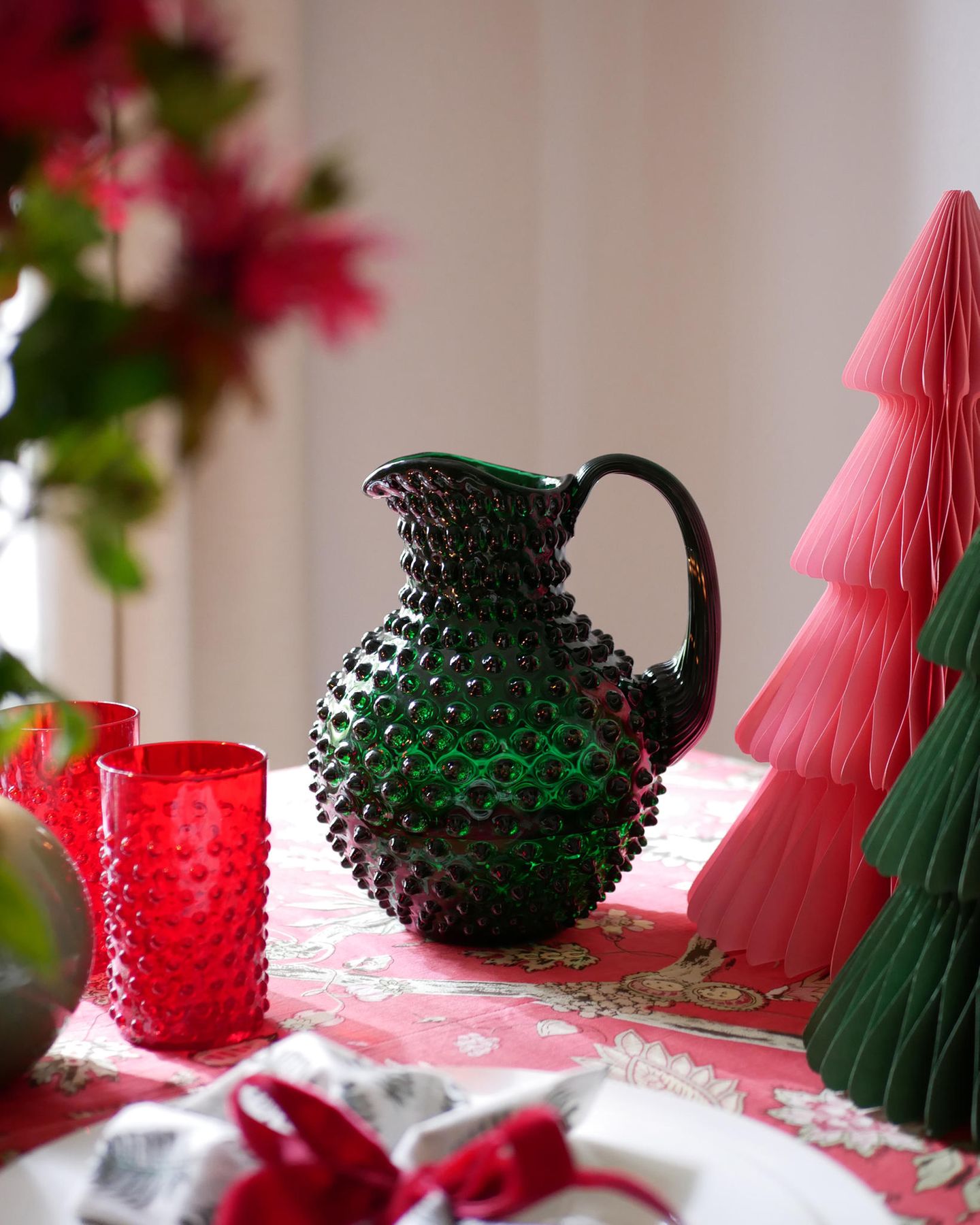 Weihnachtliches Tischgeschirr in Rot, Smaragdgrün und Rosa sowie gefaltete Papiertannenbäume