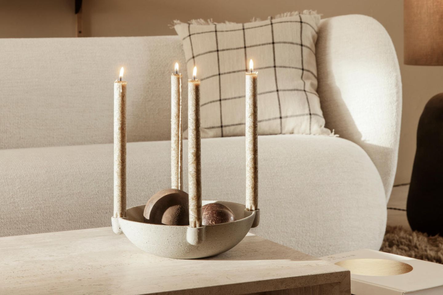 Kerzenhalter für 4 Stabkerzen steht auf einem Couchtisch in einer Wohnzimmerszenerie mit Holzregal und weißem organischen Sofa