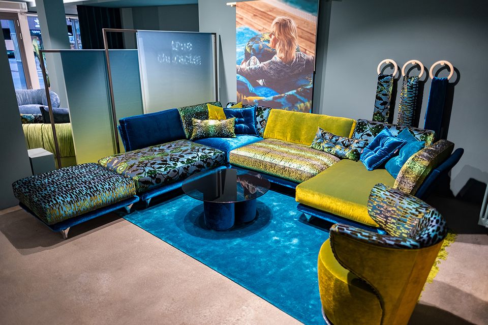 Großes Sofa in knalligem gelb-grün und blau stehen in einem Showroom