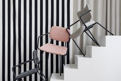 Graue und rosa Stühle auf weißer Treppe